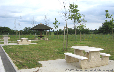 Neat picnic tables next to roadside parking in the Garonne aire