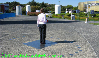 A human gnomon is part of this sundial, with rocket stages, the galaxy maze and the Astralia building beyond.