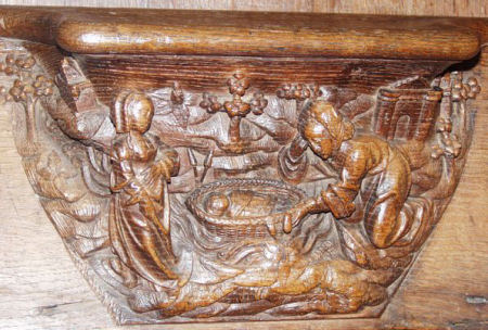 Misercord showing baby Moses being found in a basket by the river Nile.