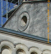 Oculus on Romanesque church, with Roman arches below.